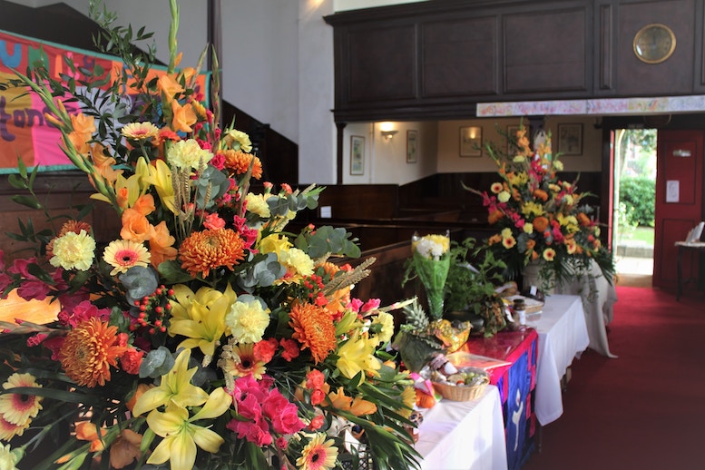 葬儀場の祭壇の画像で、いろいろな花が飾られてある