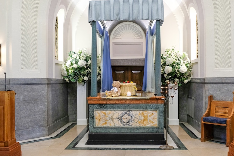 葬儀会場の祭壇の画像で、白い花やぬいぐるみなどが飾られてある